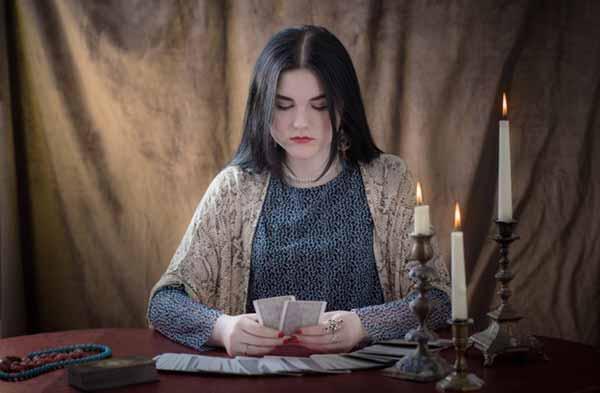 Молодая девушка гадать с картами таро Молодая девушка гадать с картами таро