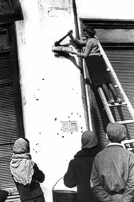 Мешканка Одеси знімає табличку з навою вулиці на честь Гітлера